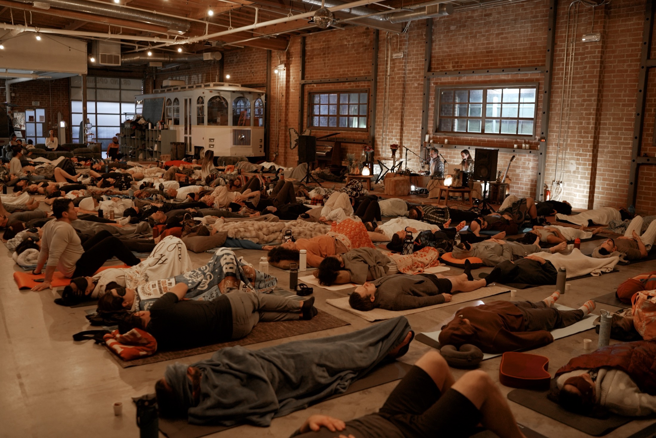 A full room of participants lying down together during a live breathwork event