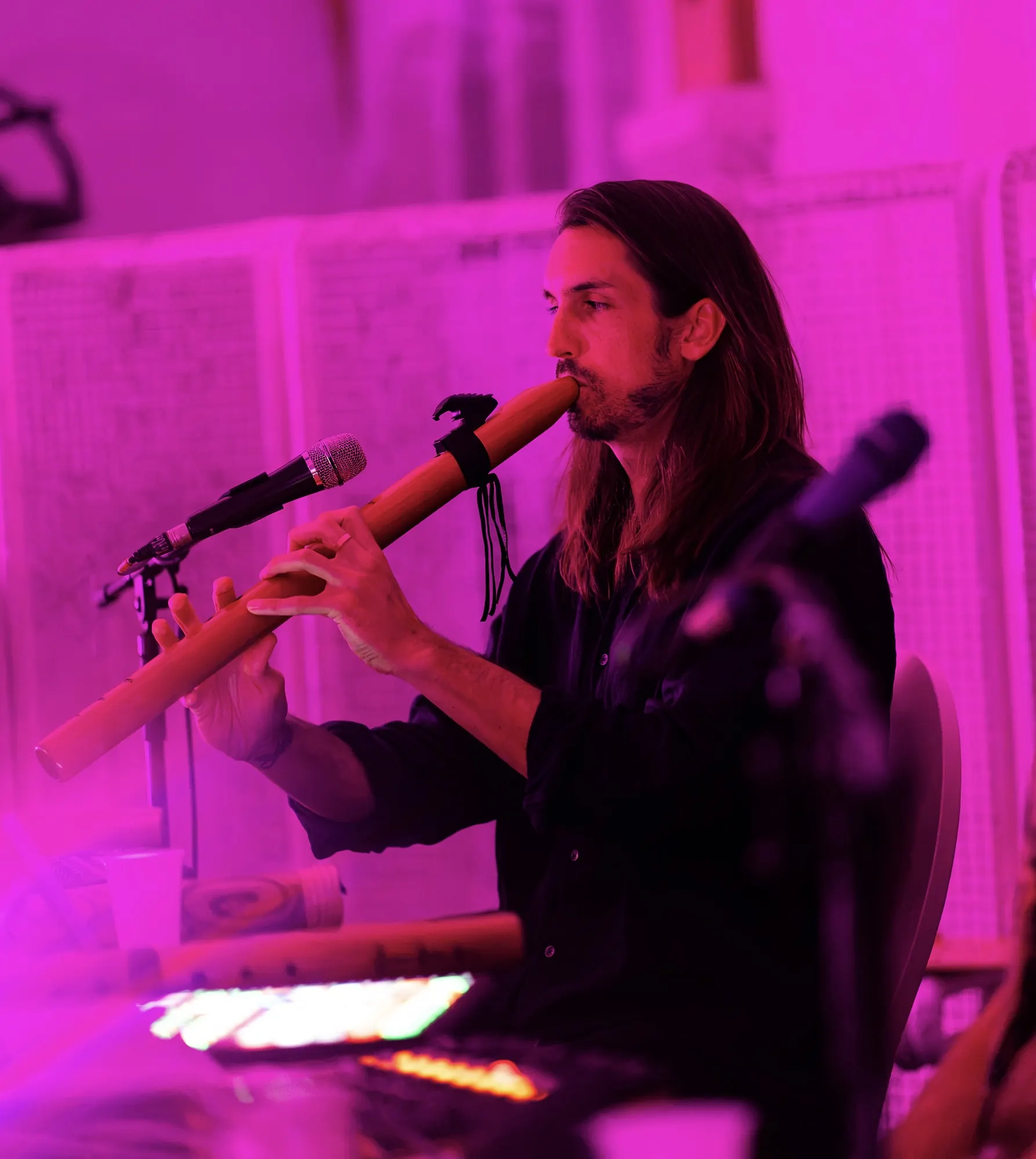 Sandy playing flute under magenta light on the Rewire Tour in Budapest