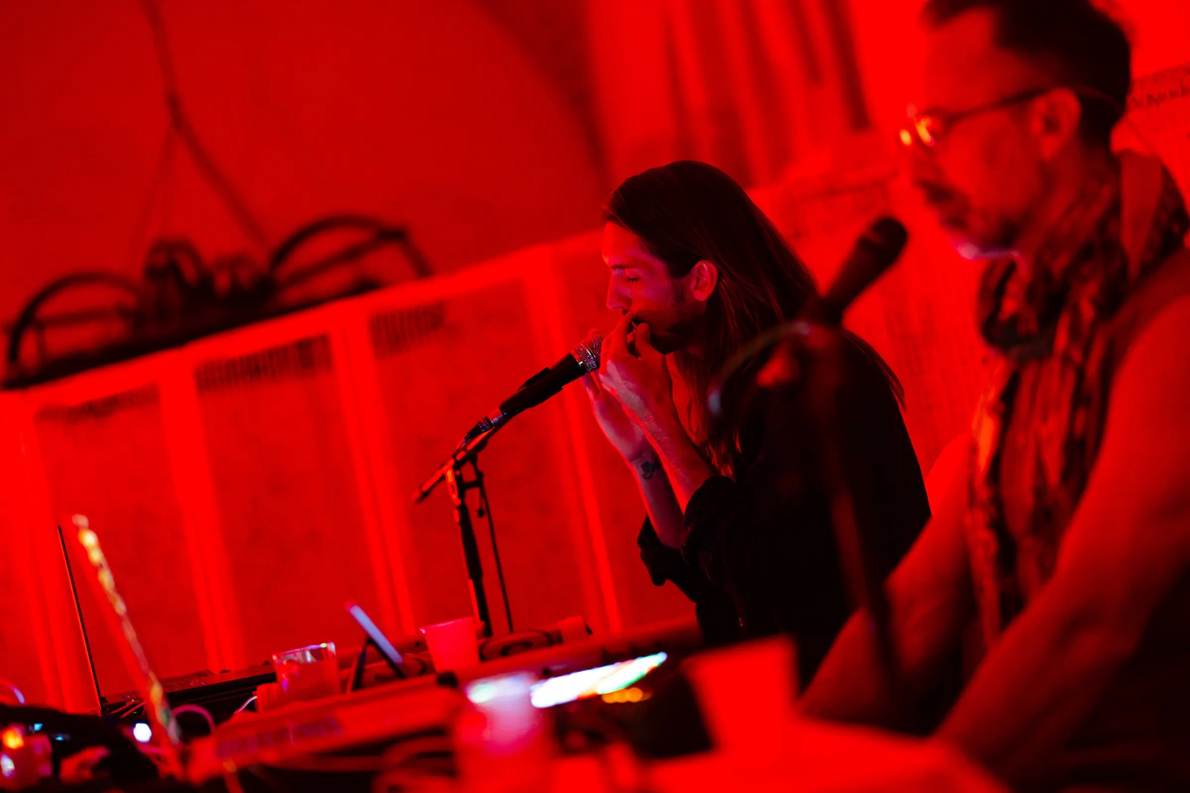 Sandy and Alex on stage in deep red light in Budapest