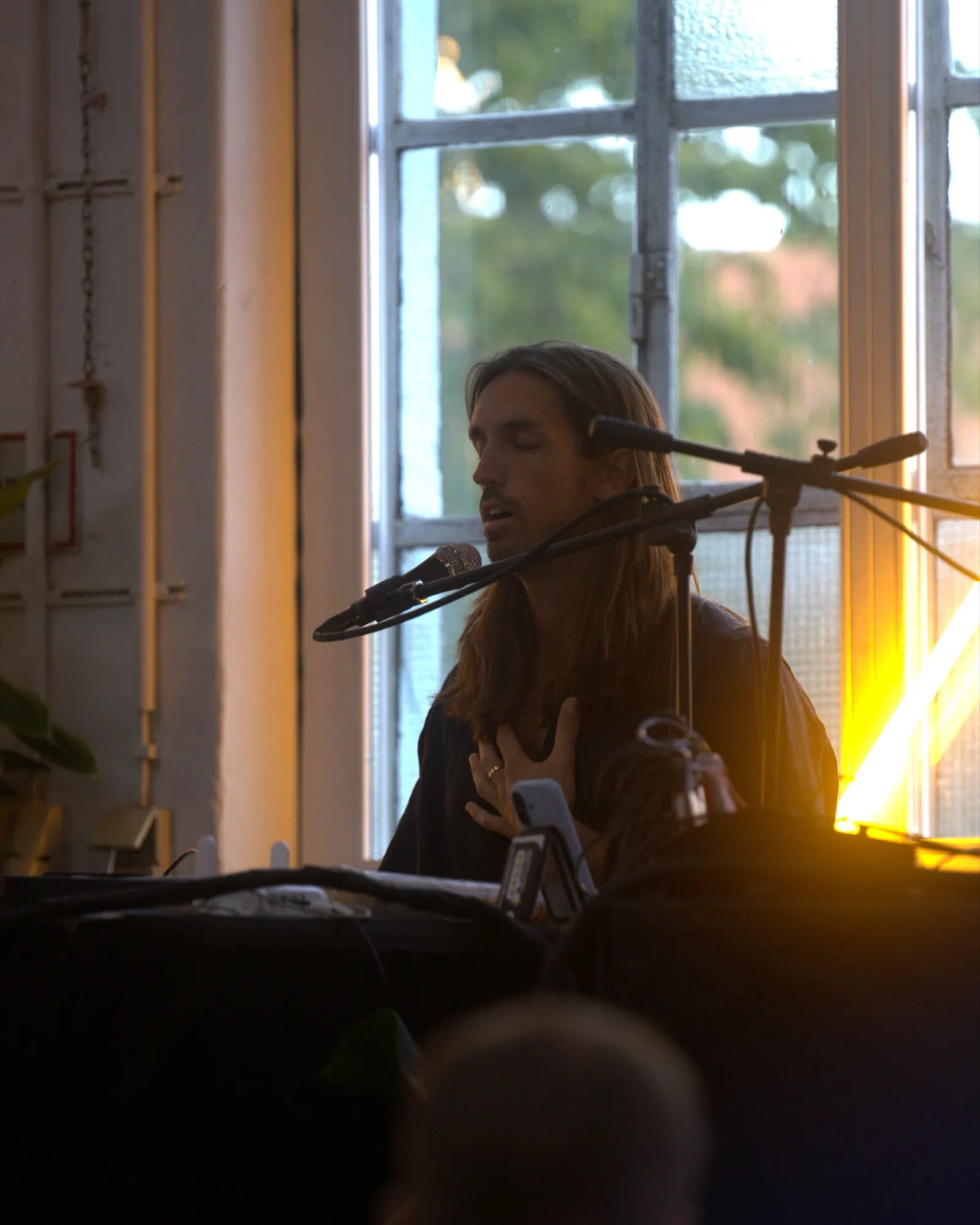 Sandy singing by a window in golden evening light in Munich